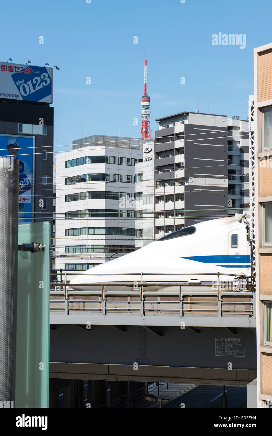 Bullet train passando tra gli edifici nel centro cittadino di Tokyo in Giappone. Foto Stock