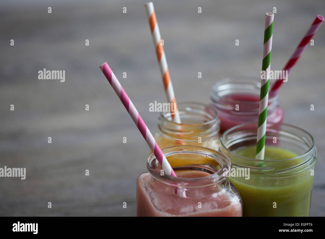 Quattro diversi sapori smoothie in vasi con cannucce Foto Stock