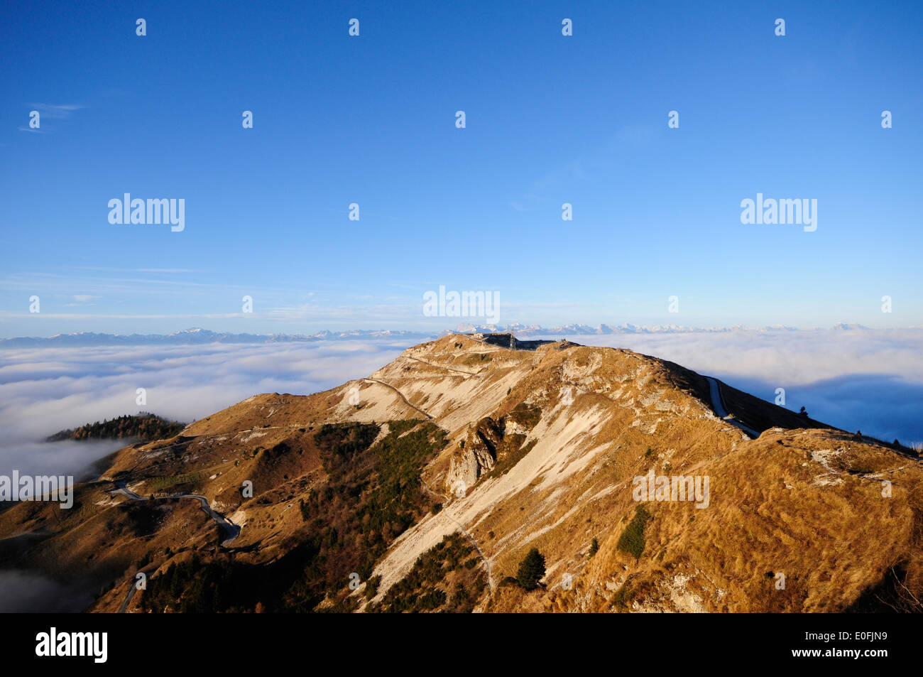 Cima della montagna con la luce che emerge dalle nuvole Foto Stock