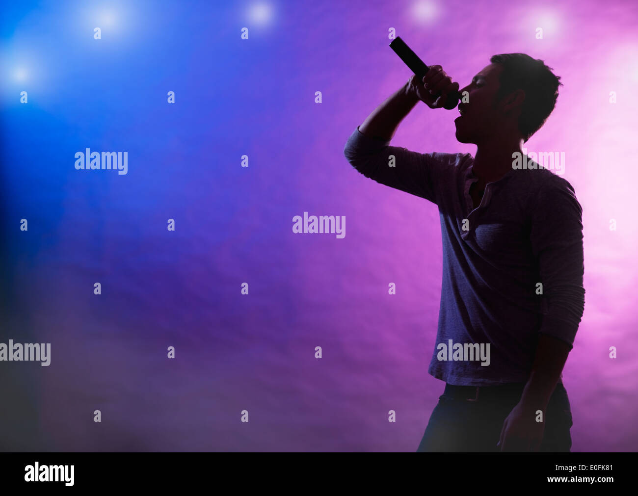 Silhouette di un cantante maschio sul palco Foto Stock