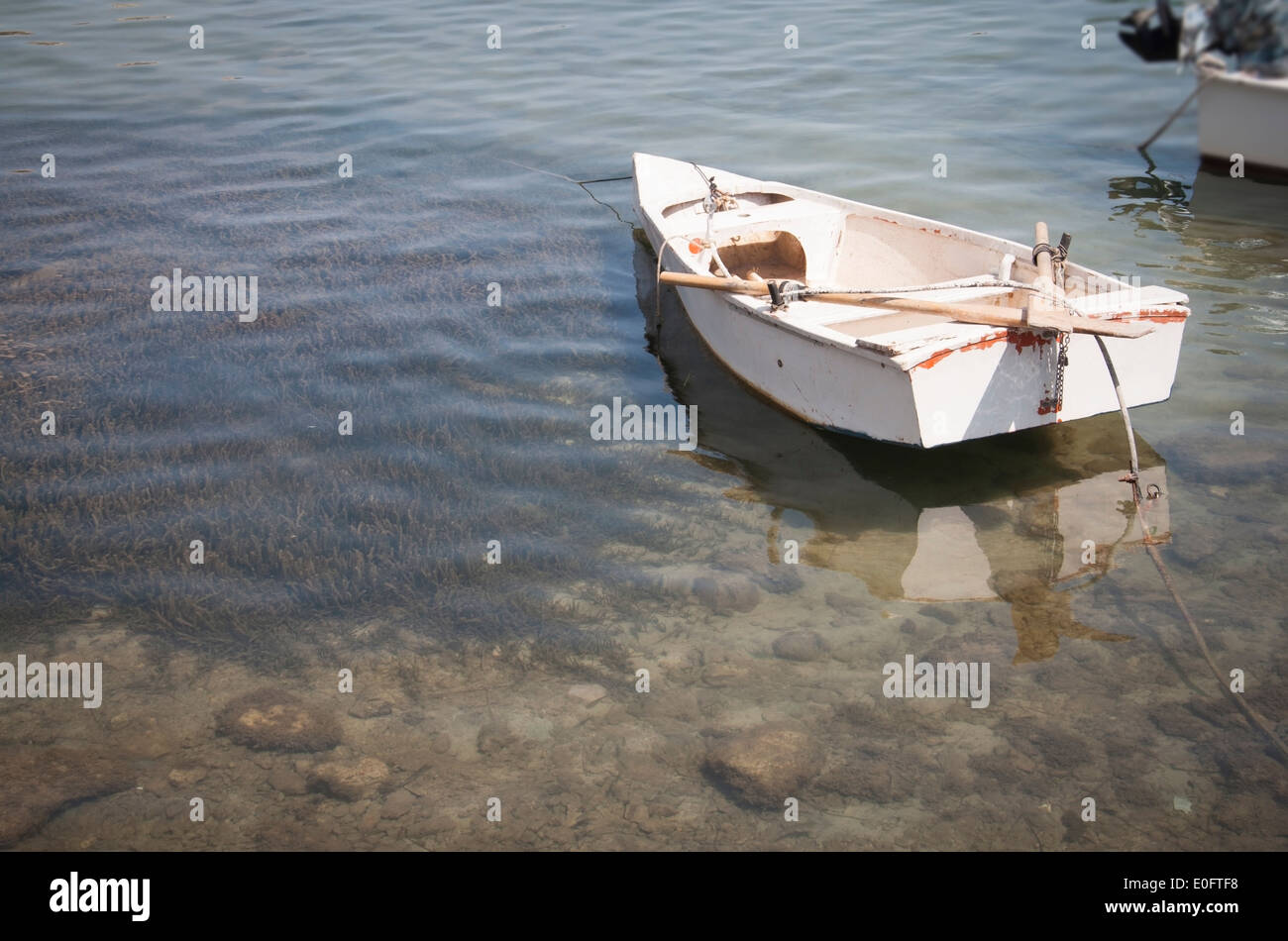 Vecchia riga bianca barca ormeggiata sulla tranquilla e poco profonde acque trasparenti. Maiorca, isole Baleari, Spagna. Foto Stock