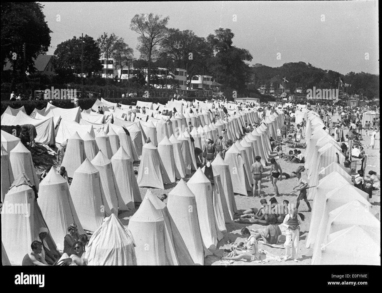 Questa immagine cattura la vita estiva sulla spiaggia vicino a Bellevue, con persone che si godono il sole e le attività in spiaggia in una storica foto in bianco e nero. Foto Stock