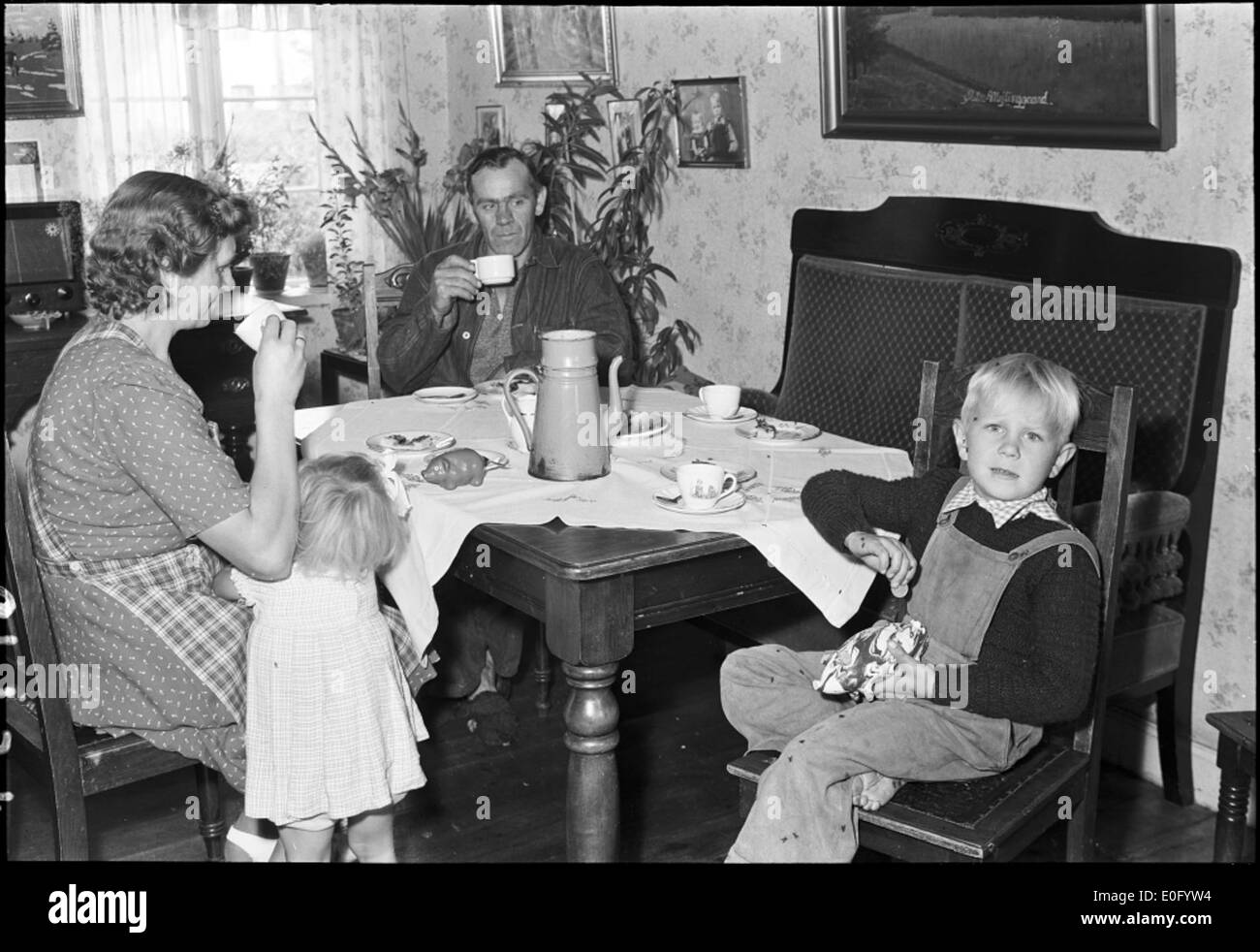 Familen om bordet med signora blå Foto Stock