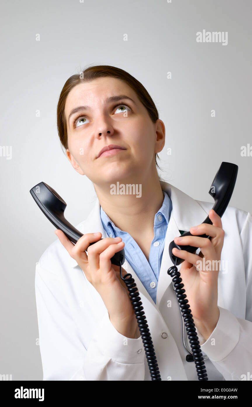 Medico infelice con i ricevitori del telefono Foto Stock