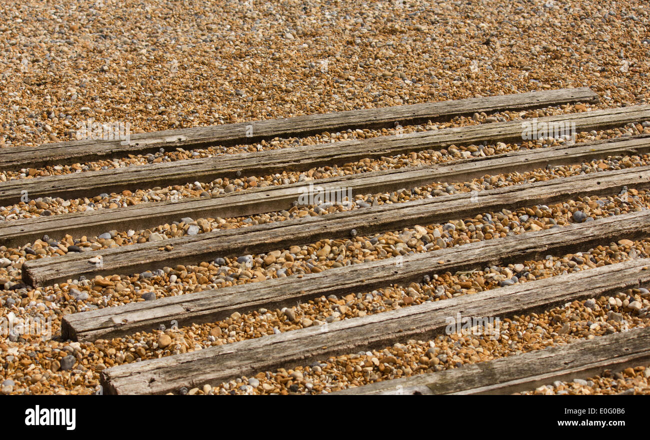 Stecche di legno sulla spiaggia che vengono utilizzati per favorire il lancio di imbarcazioni e impedisce loro di diventare incorporata nella ghiaia pietre Foto Stock