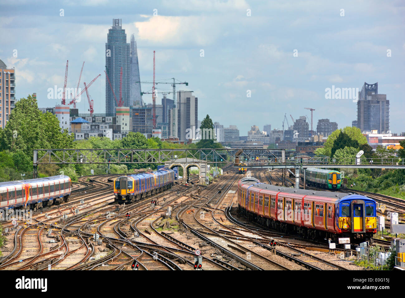 I treni e i binari dei trasporti pubblici di Clapham Junction sono molto trafficati, con la St Georges Tower Vauxhall e i punti di riferimento di Shard sullo skyline di Londra oltre l'Inghilterra UK Foto Stock
