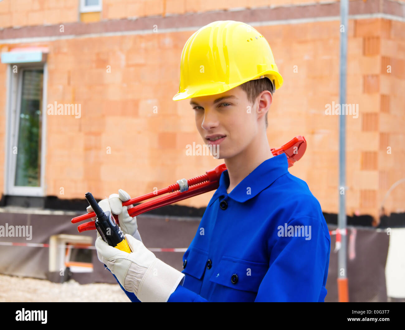 Un apprendista / partecipante. Operaio edile sul sito di costruzione con casco., Ein Lehrling / Azubi. Bauarbeiter auf Baustelle mit Foto Stock