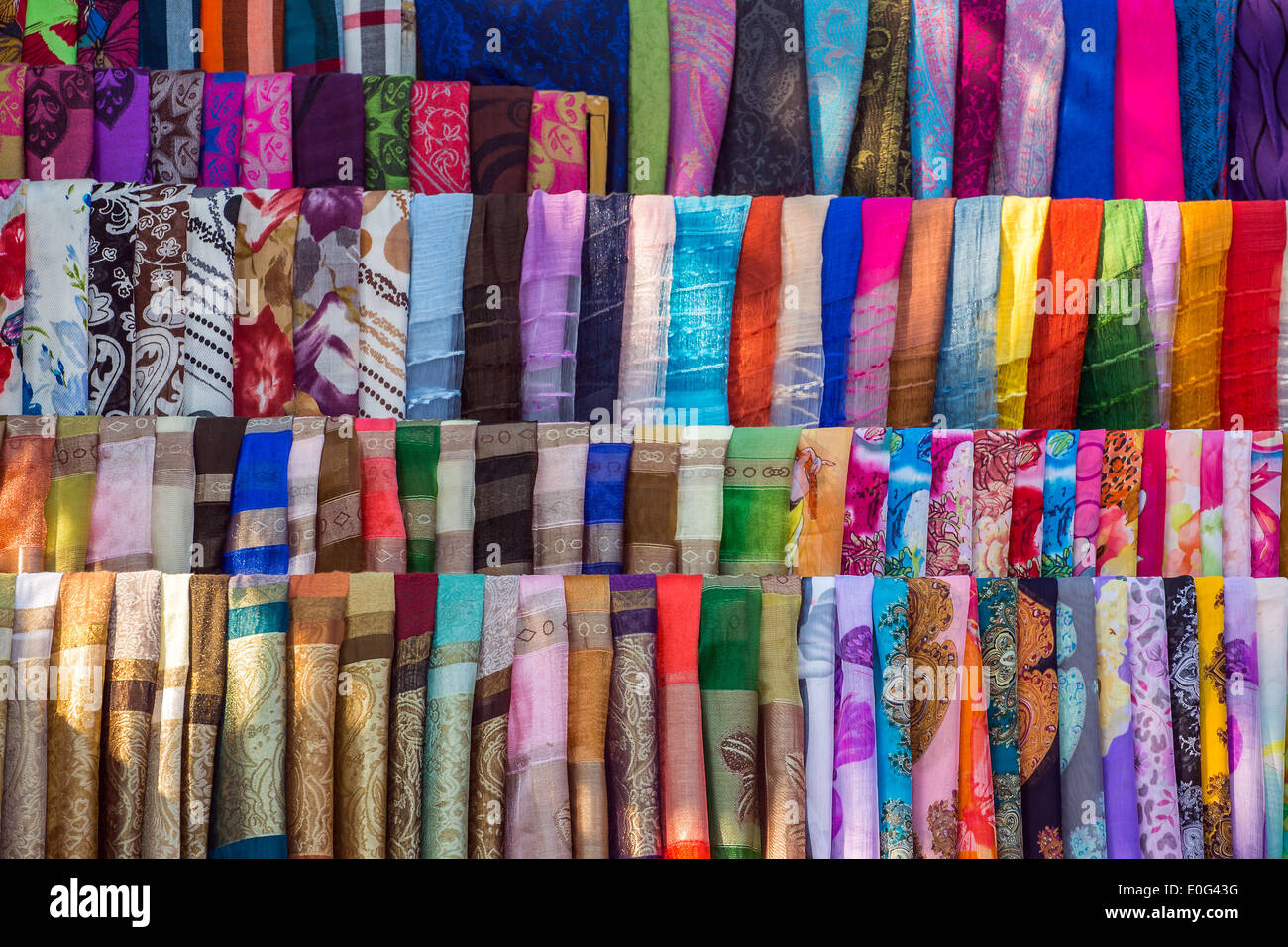 Varie di tessuti colorati e scialli in un mercato in stallo Foto Stock