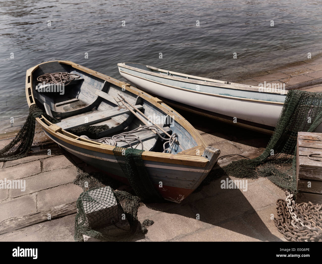 Vecchie barche di legno con reti da pesca su una riva Foto Stock
