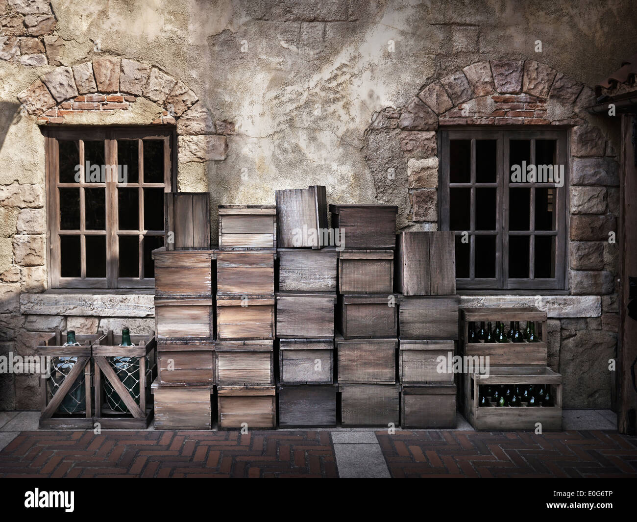 Le bottiglie di vino e casse di legno in piedi presso la parete al di fuori di una vecchia casa italiana Foto Stock
