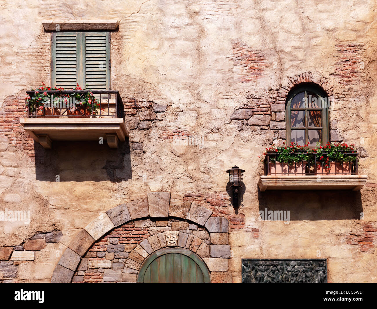 Parete di una vecchia casa rustica con fiori sotto windows, antica architettura in stile veneziano Foto Stock