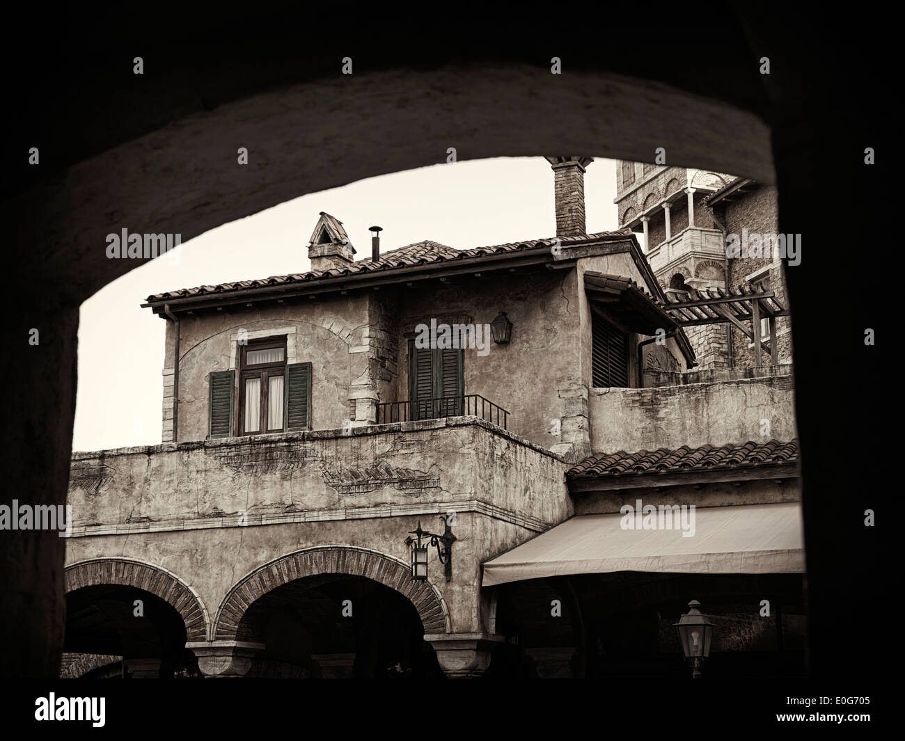 Foto artistiche di antica casa europea sotto un arco, architettura veneziana dettaglio, in bianco e nero dai toni seppia Foto Stock