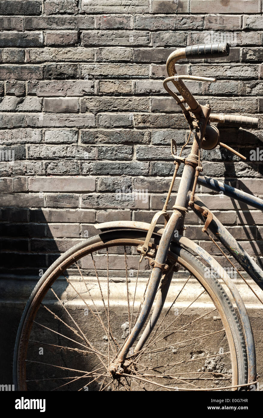 Vecchia bicicletta appoggiata contro un muro di mattoni in un hutong cinese  Foto stock - Alamy
