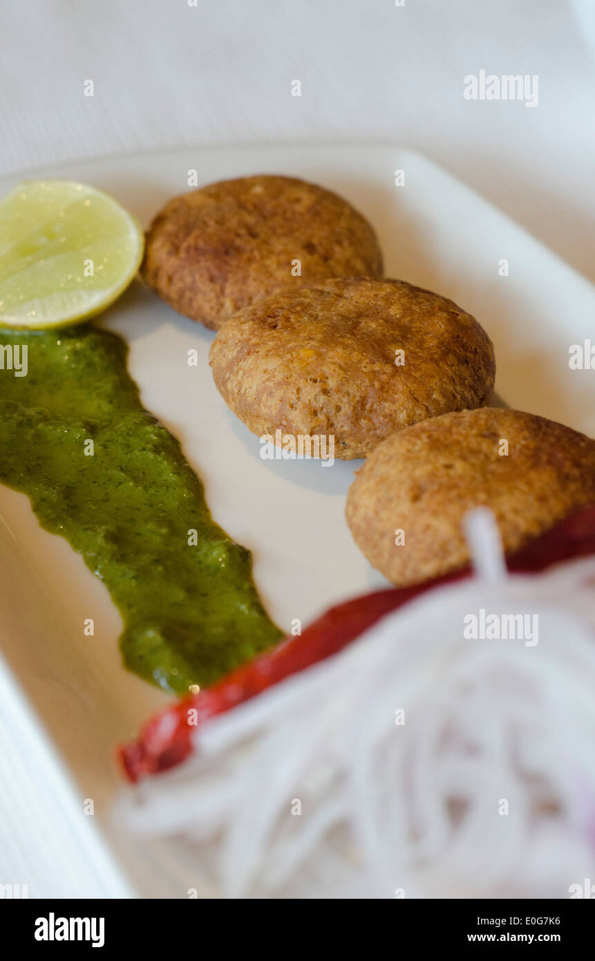 Fritte, piccante crocchette di carne con chutney verde, cipolle e limone (Shaami Kebab) Foto Stock