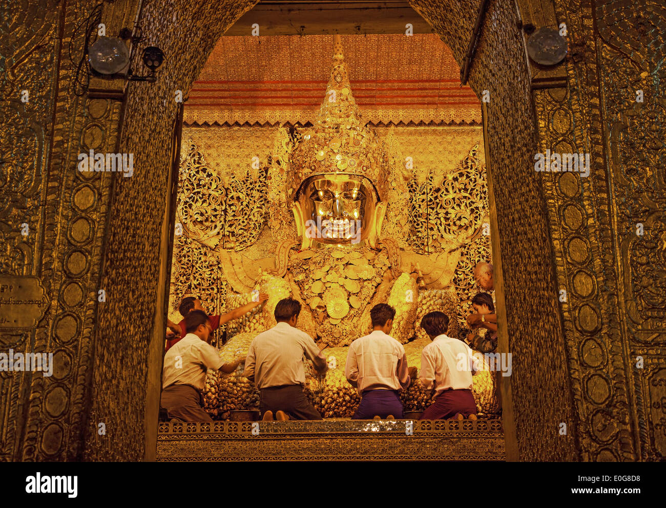 I credenti birmano culto statua del Buddha incollando foglie d'oro petali in Mahamuni Pagoda, Foto Stock