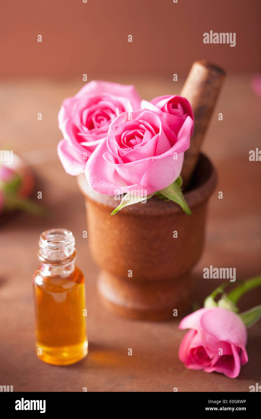 Mortaio con rose fiori e olio essenziale per aromaterapia e spa Foto Stock