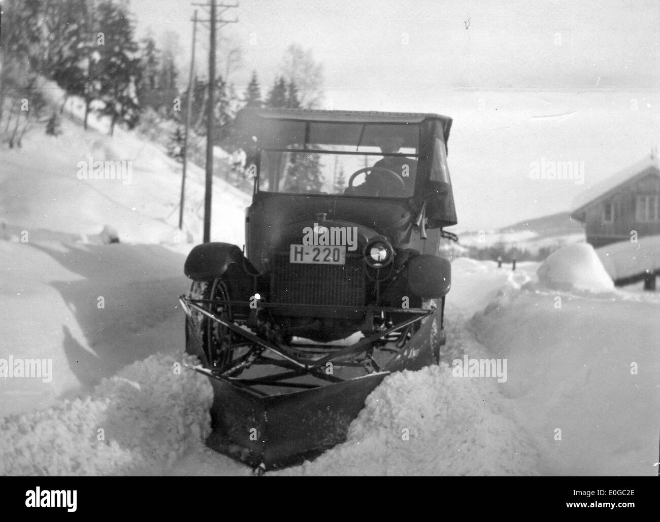 Questa immagine raffigura l'operazione di aratura della neve sulla strada tra Sauland e Notodden nel febbraio 1926, mostrando il paesaggio invernale e l'uso di aratri per la pulizia delle strade. Foto Stock