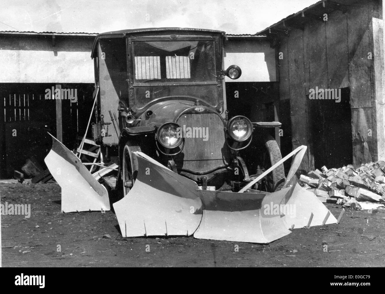 Questa fotografia, scattata tra il 1924 e il 1925, mostra un aratro innevato attaccato a un'auto, che rimuove la neve dal lato della strada in un paesaggio invernale in Norvegia. Foto Stock