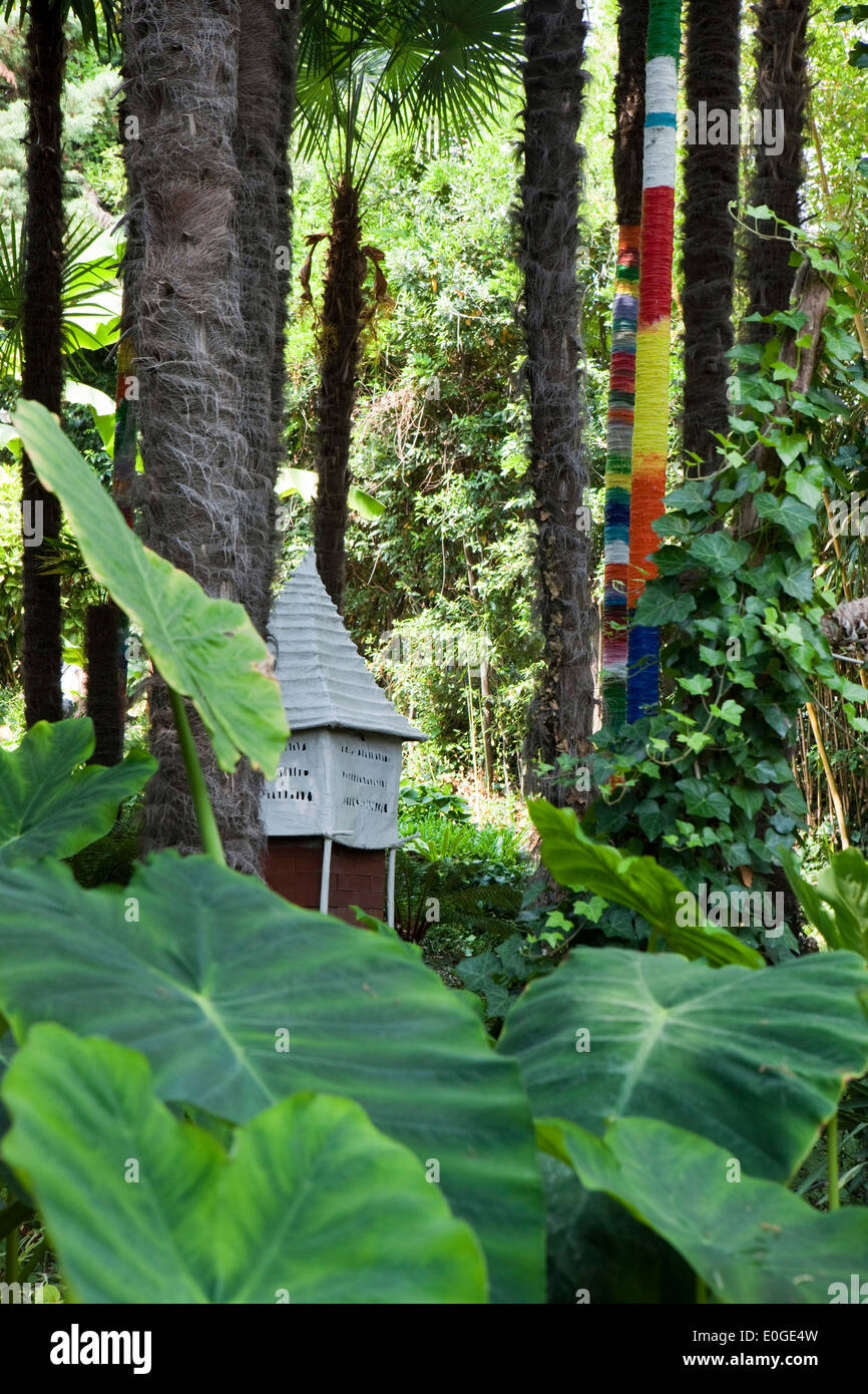 Piccola casa e dipinto di tronchi di alberi a Andre Hellers' giardino, Giardino Botanico, Gardone Riviera sul lago di Garda, Lombardia, Italia, Foto Stock