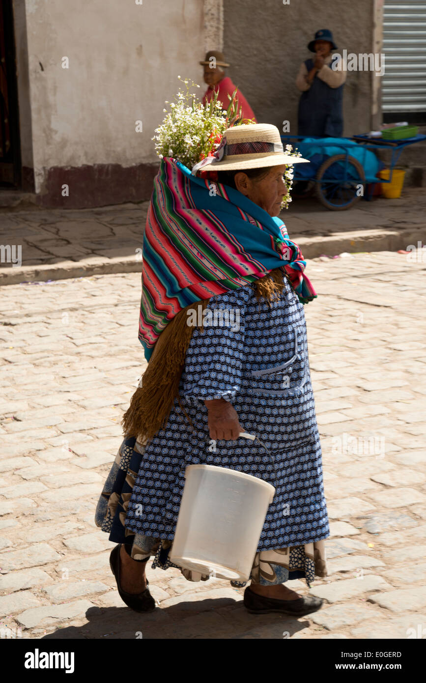 Donna boliviana a piedi lungo una strada a Copacabana, Bolivia. Foto Stock