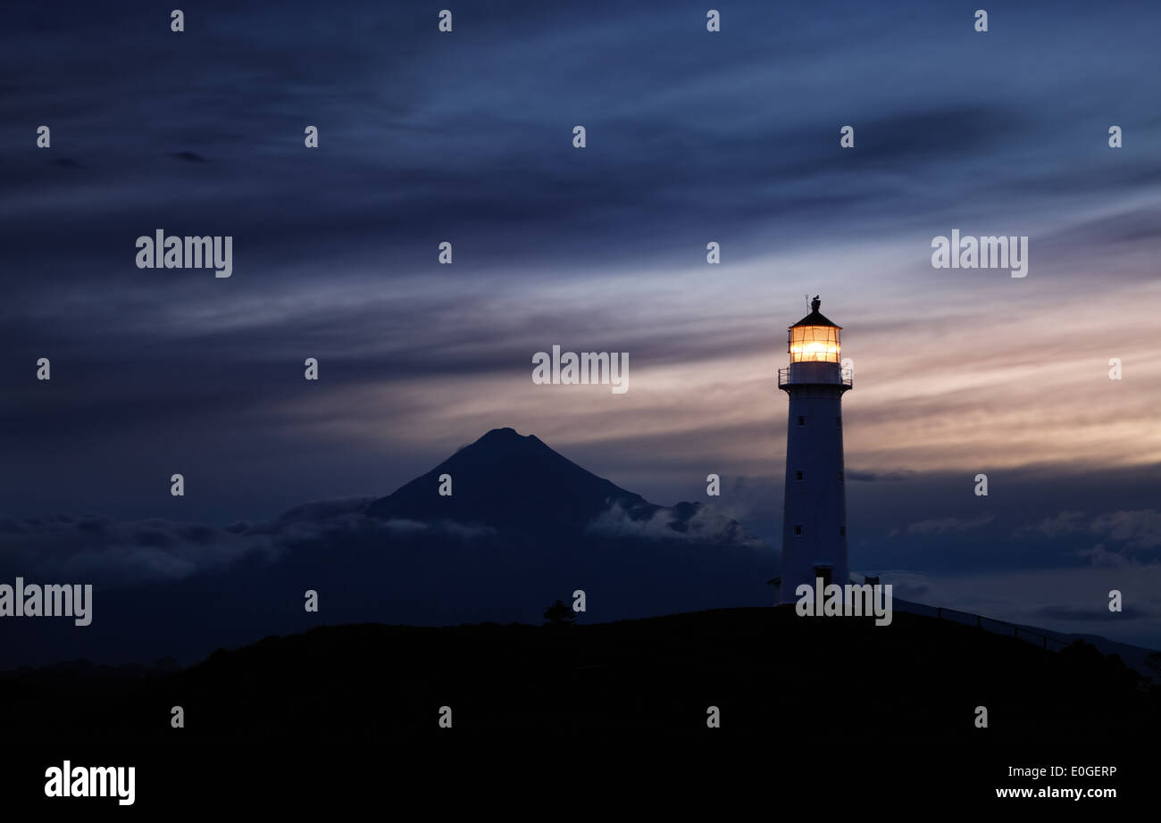 Faro di Egmont e Taranaki montare su sfondo, Nuova Zelanda Foto Stock