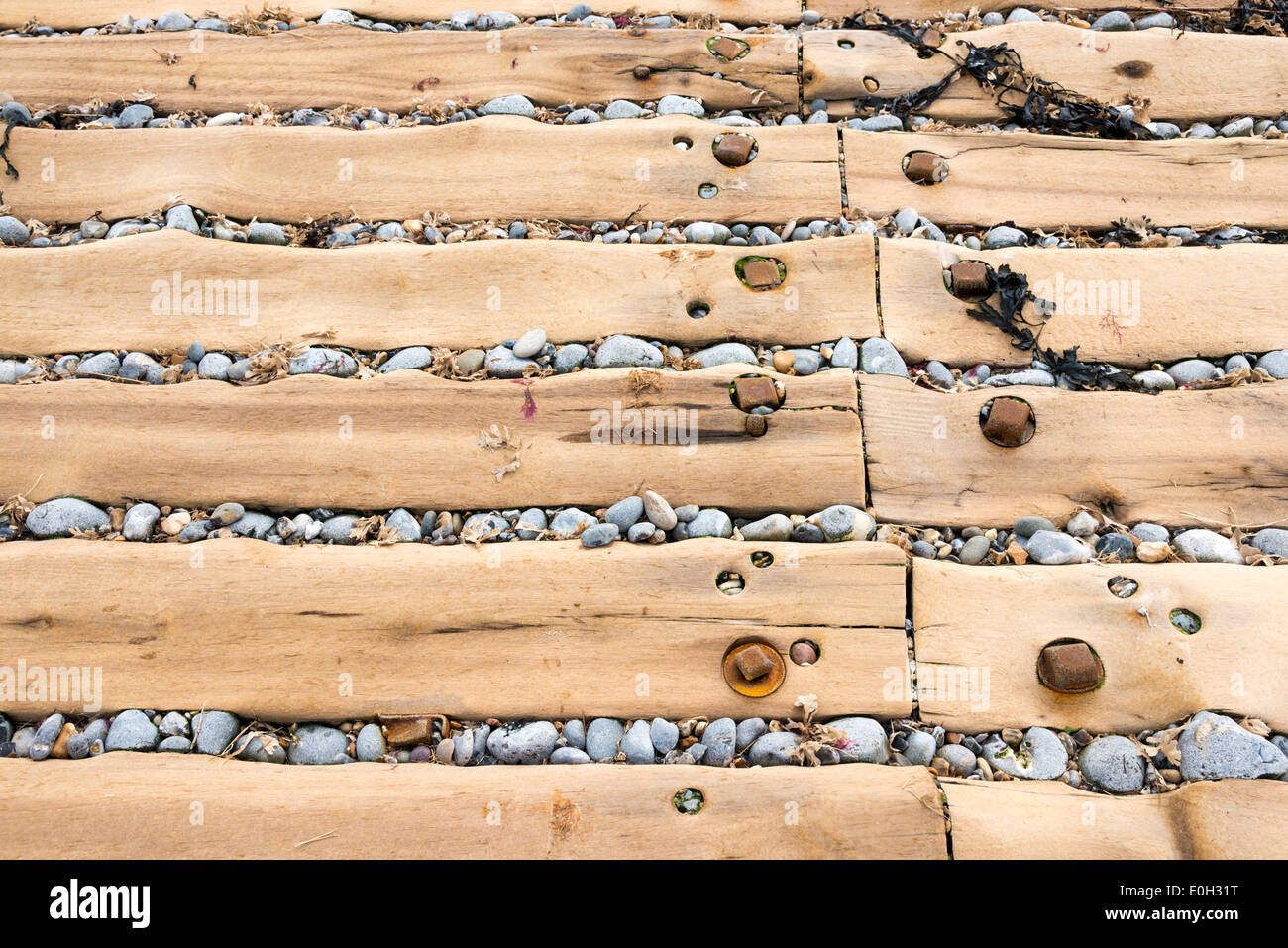 Immagine astratta, close up delle tavole di legno e ciottoli in uno scalo a Sheringham NORFOLK REGNO UNITO Foto Stock