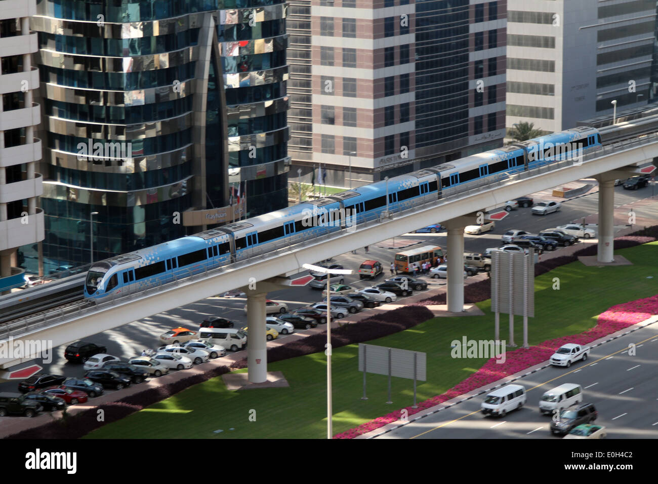 Un treno sulla linea rossa della metropolitana di Dubai si muove oltre gli alti edifici e il traffico della Sheikh Zayed Road a Dubai. Foto Stock