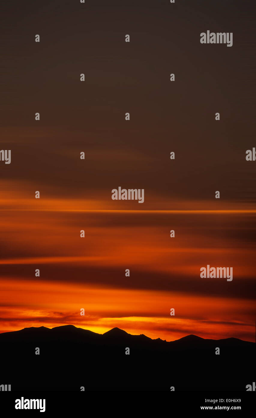 Shilhouette del Puy du Sancy mountain al tramonto con il cielo rosso, Francia Foto Stock