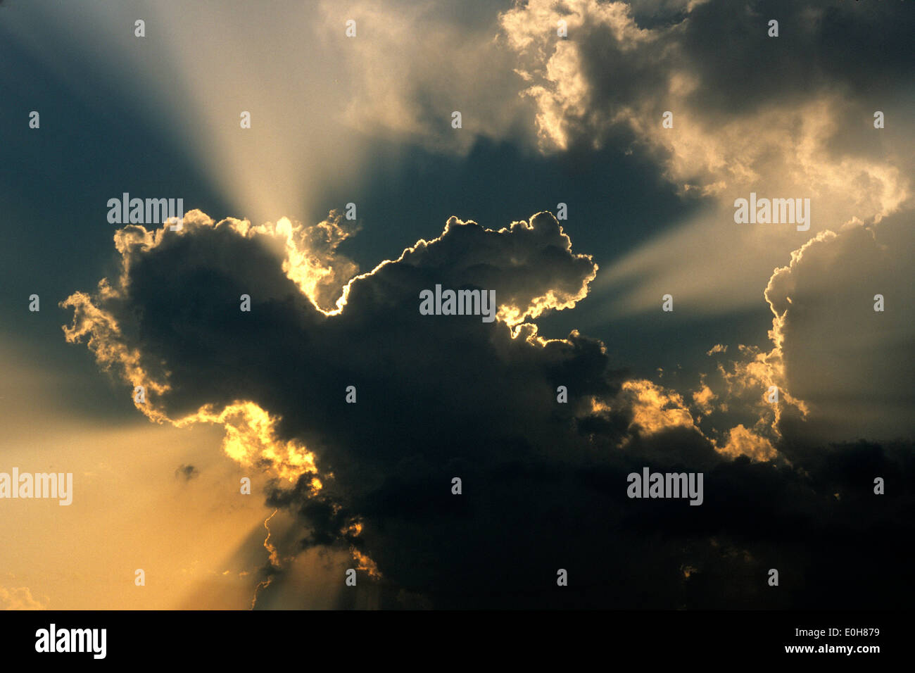 Raggi solari, sunburst, raggi del sole dietro le nuvole di un cielo drammatico Foto Stock