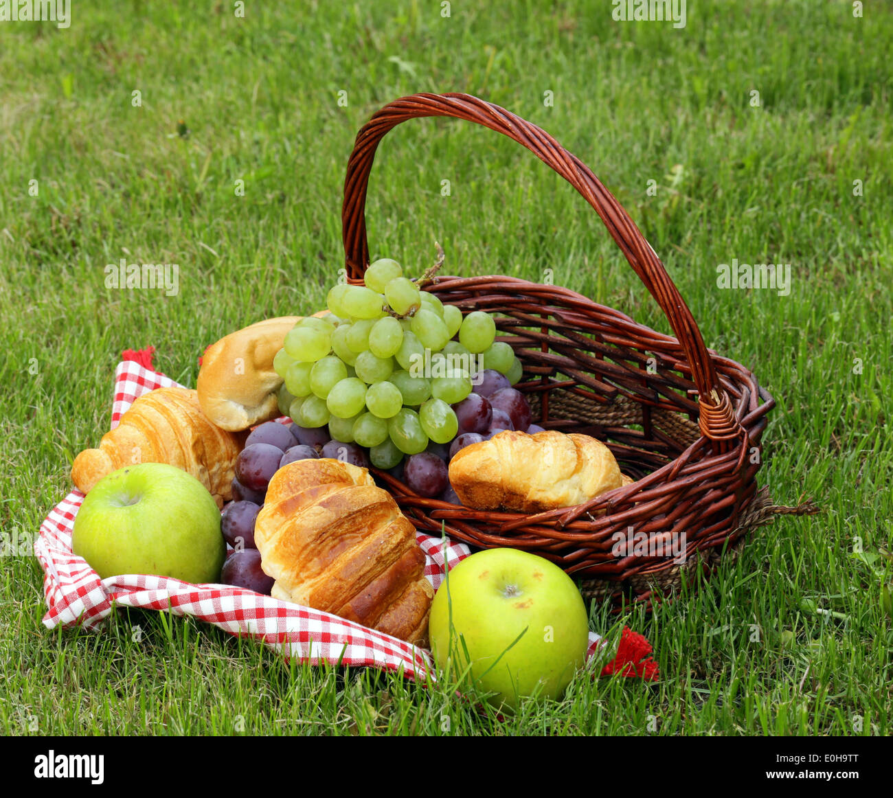 Pic nic sul prato verde con uve e croissant Foto Stock
