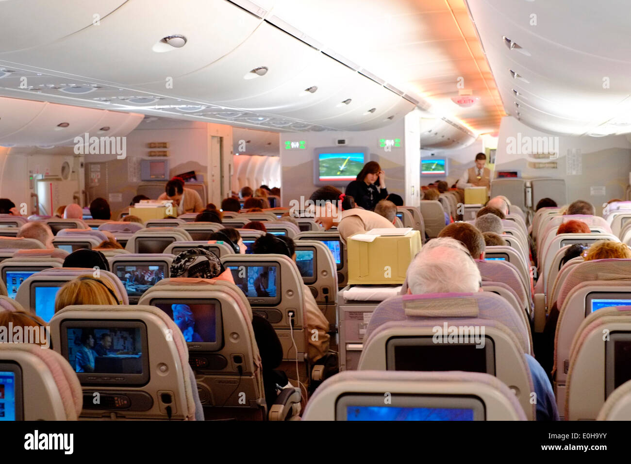 Hostess che serve rinfreschi da un carrello nell'economia cabina di un A380 Emirates airbus Foto Stock