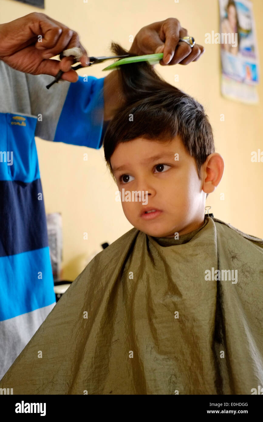 Little Boy avente un taglio di capelli in un piccolo villaggio home salon in Giava Est Indonesia Foto Stock