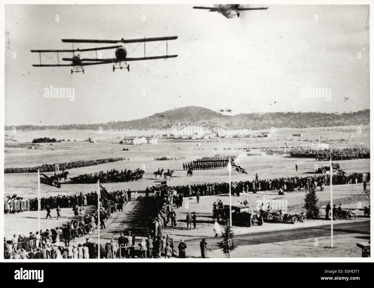 Questa immagine del 1927 mostra York Park a Canberra durante una visita reale, con aerei sopra la testa. La scena cattura la presenza reale nella capitale dell'Australia, con gli aerei che simboleggiano i progressi tecnologici dell'epoca. Foto Stock