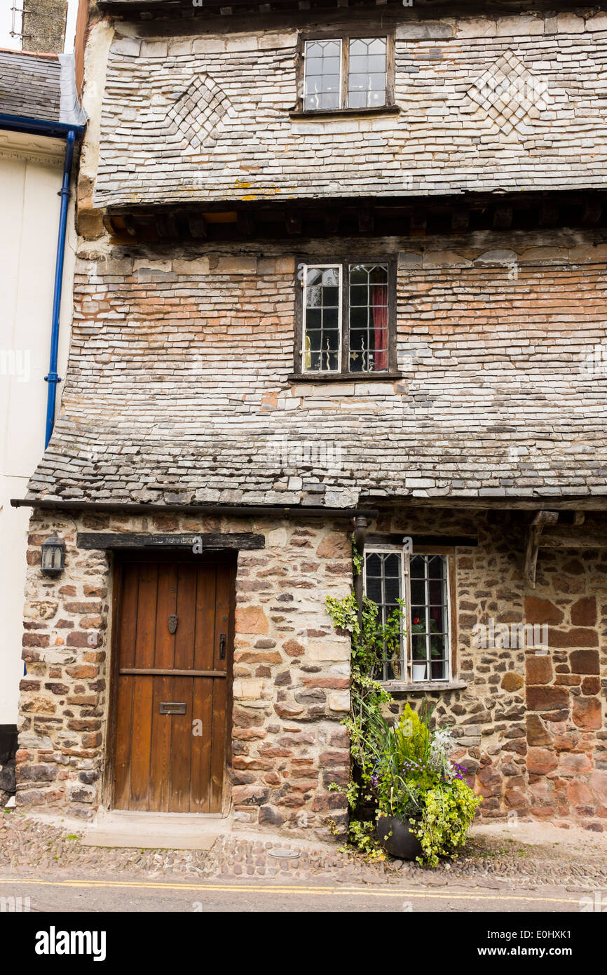 Un sistema a più livelli, tetto di tegole roofline passo su un cottage nella piccola città di Dunster, Devon, Inghilterra Foto Stock