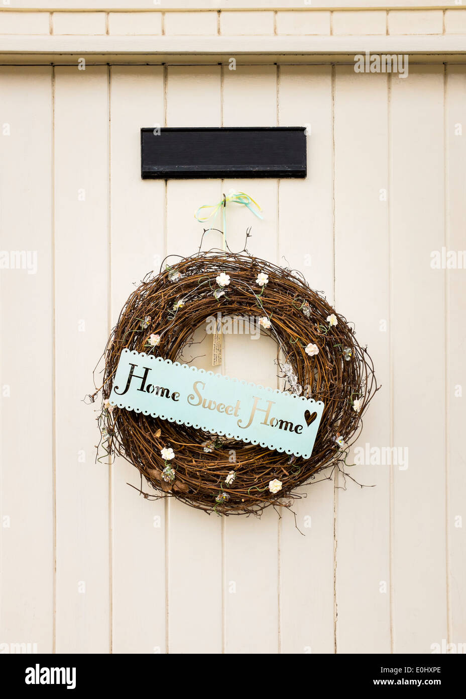 Un "Home Sweet Home" segno/corona si blocca su una porta in inglese nel villaggio di Dunster, Devon, Inghilterra Foto Stock
