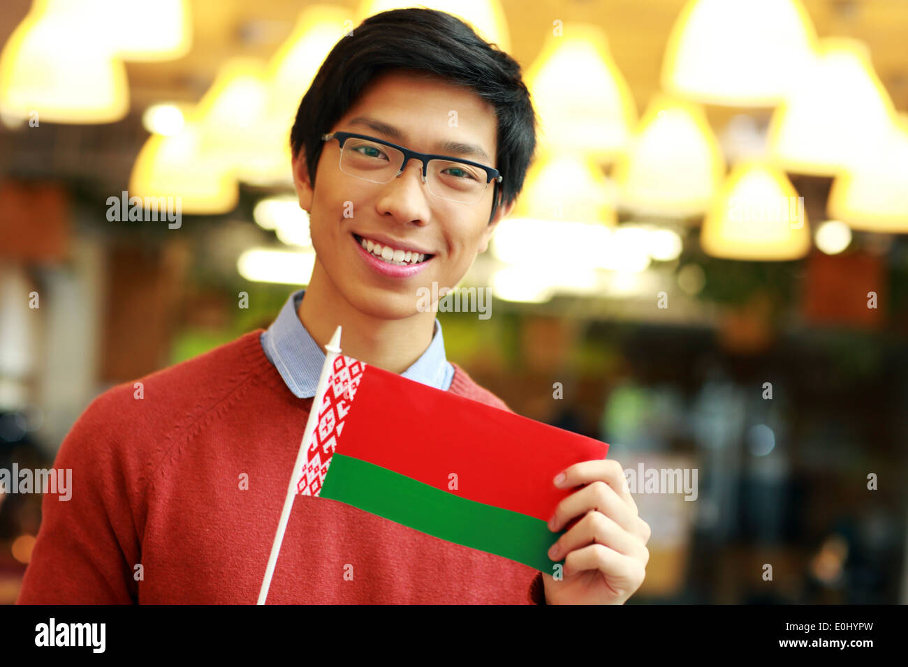 Felice giovane ragazzo asiatico holding bandiera della Bielorussia Foto Stock