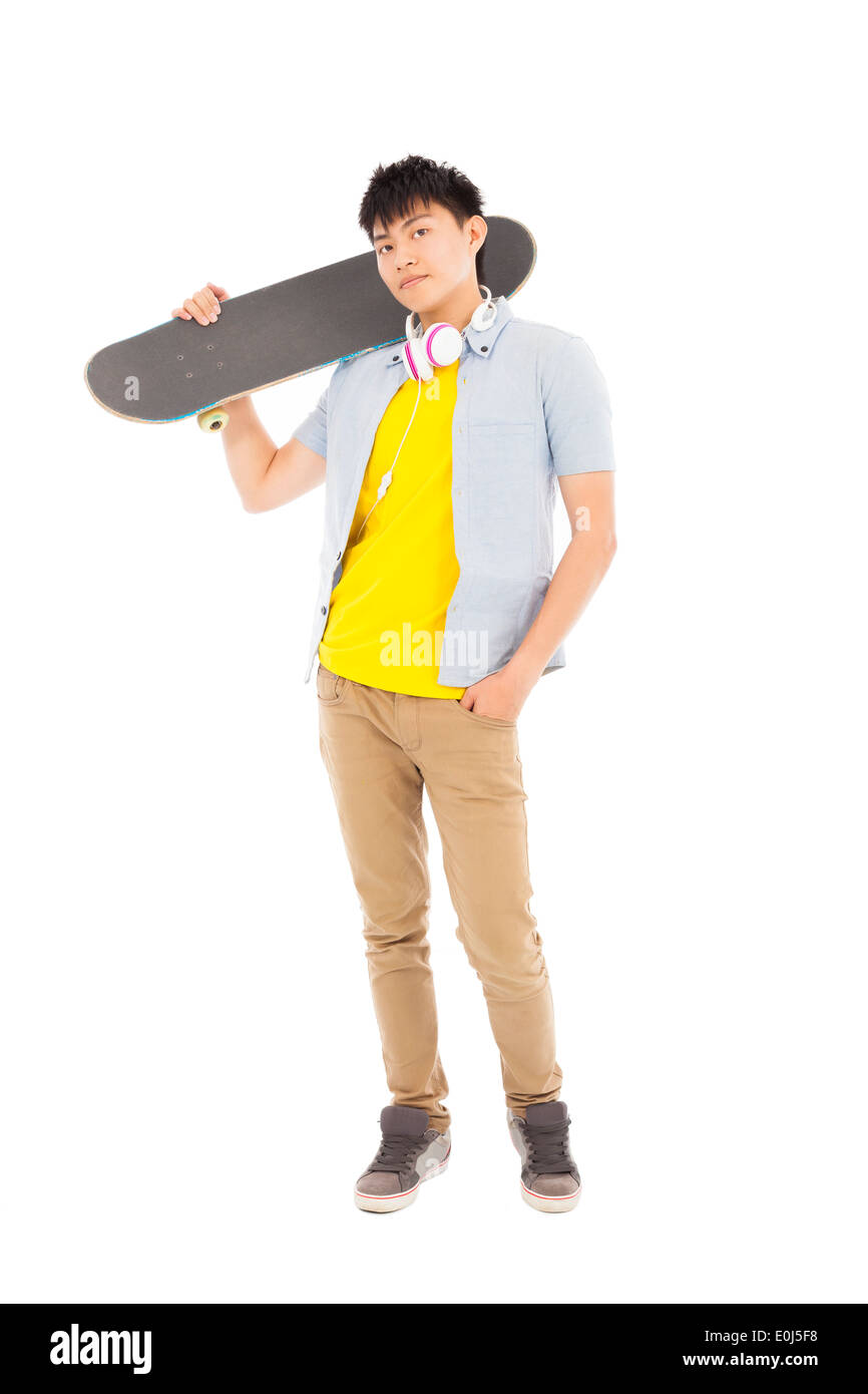 Giovane uomo in piedi e tenendo premuto uno skateboard Foto Stock