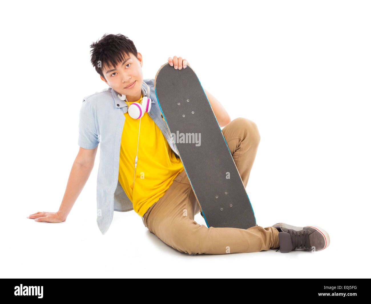 Cool uomo seduto e tenendo premuto uno skateboard Foto Stock