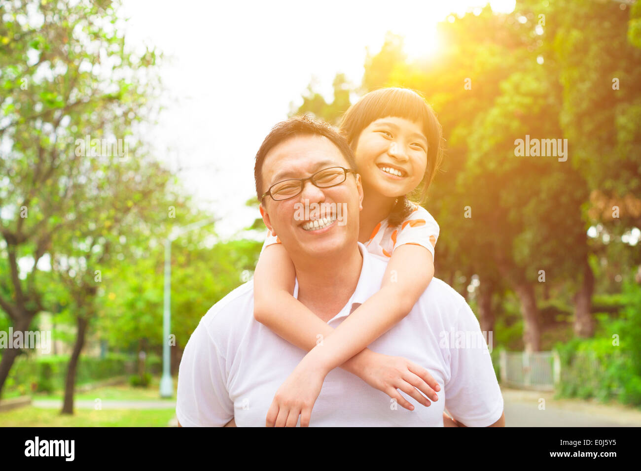 Felice il padre e la bambina con il tramonto sullo sfondo Foto Stock