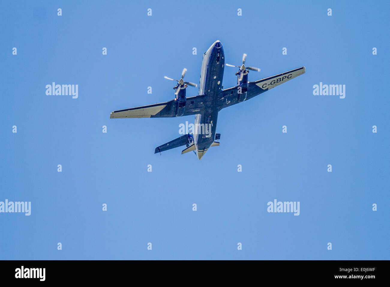 Beech 1900C-2. Twin prop aereo banking e overhead contro un cielo blu. Foto Stock