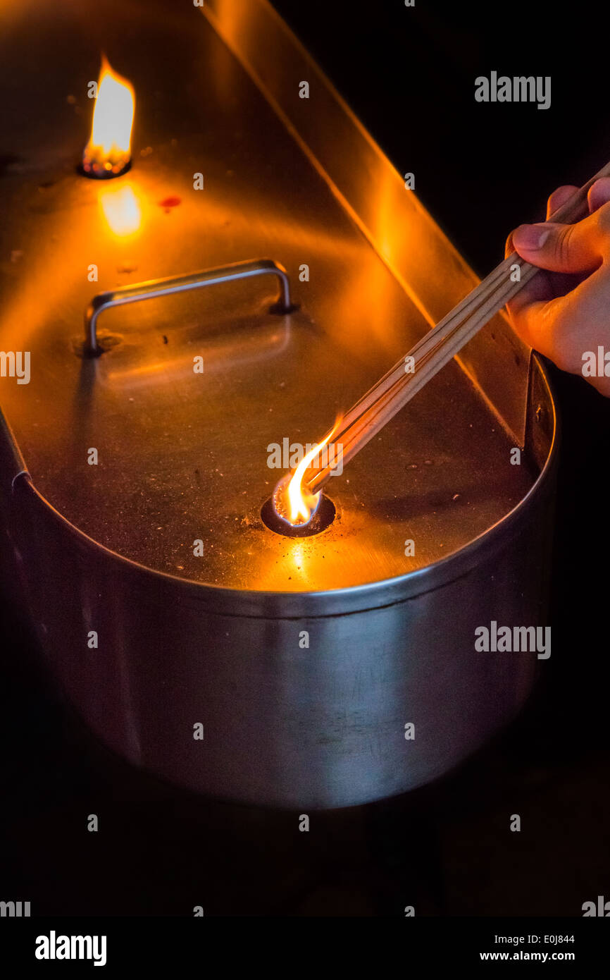 La mano di un uomo bruciare bastoncini di incenso Foto Stock