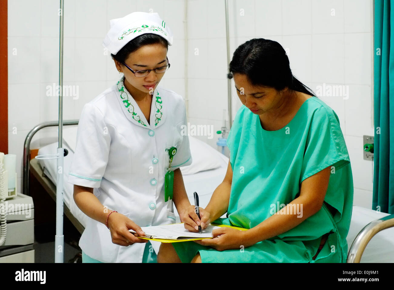 Donna indonesiana prima del suo taglio cesareo c la sezione Funzionamento firma forme di autorizzazione con infermiera in malang east java indonesia Foto Stock