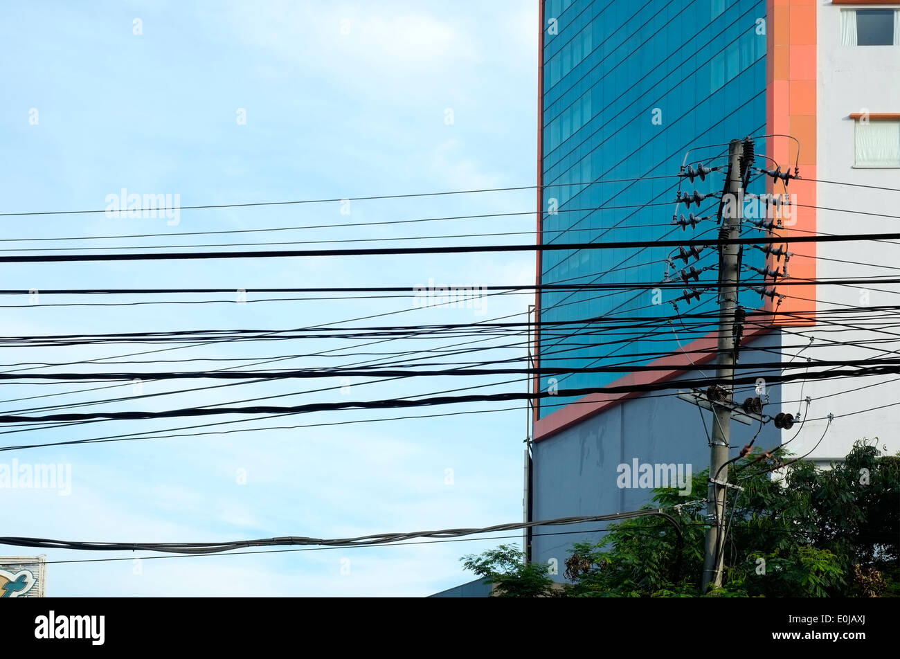 Molti cavi di energia elettrica al di sopra di una strada comunemente visto in Indonesia Foto Stock