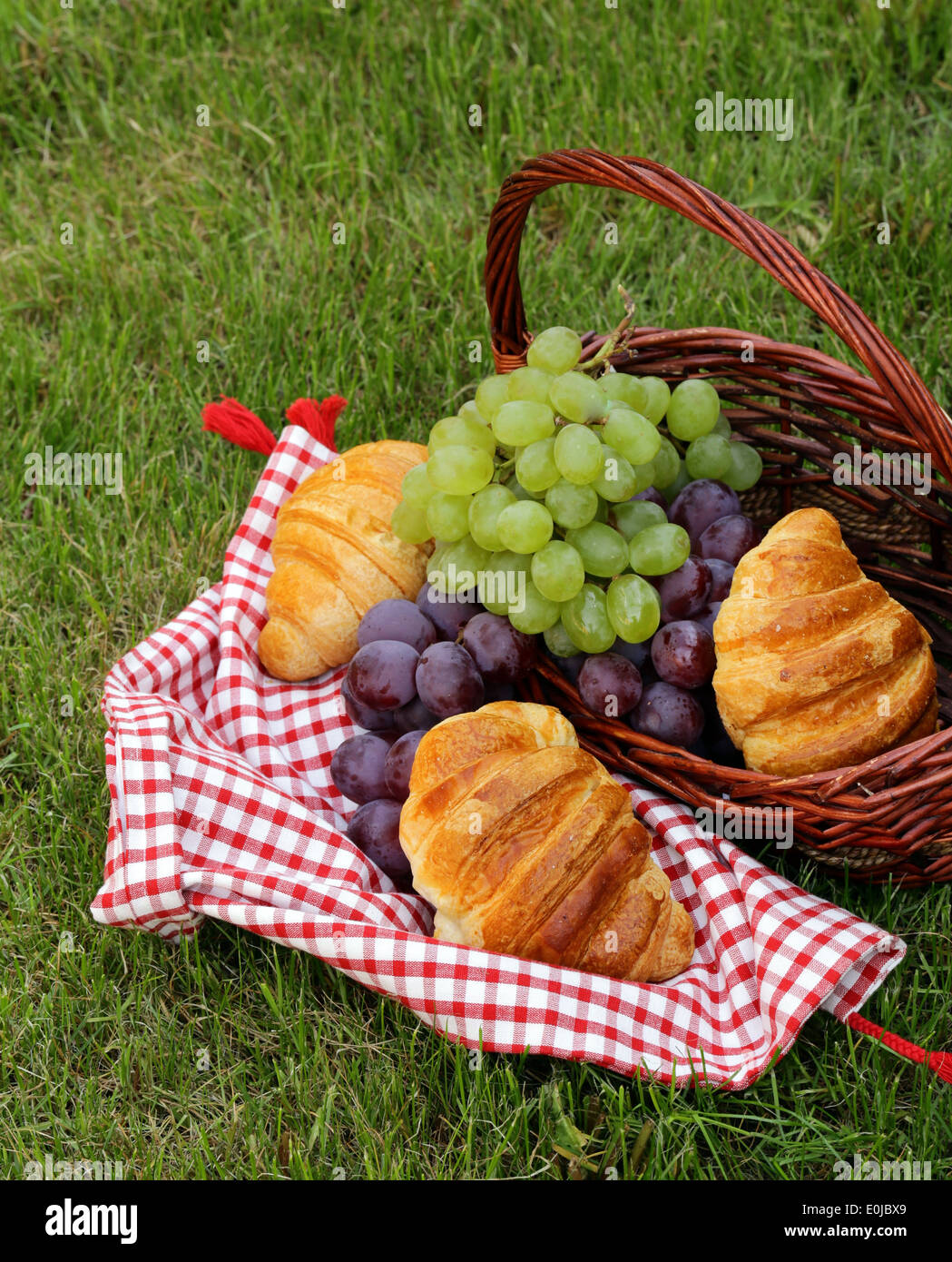 Pic nic sul prato verde con uve e croissant Foto Stock