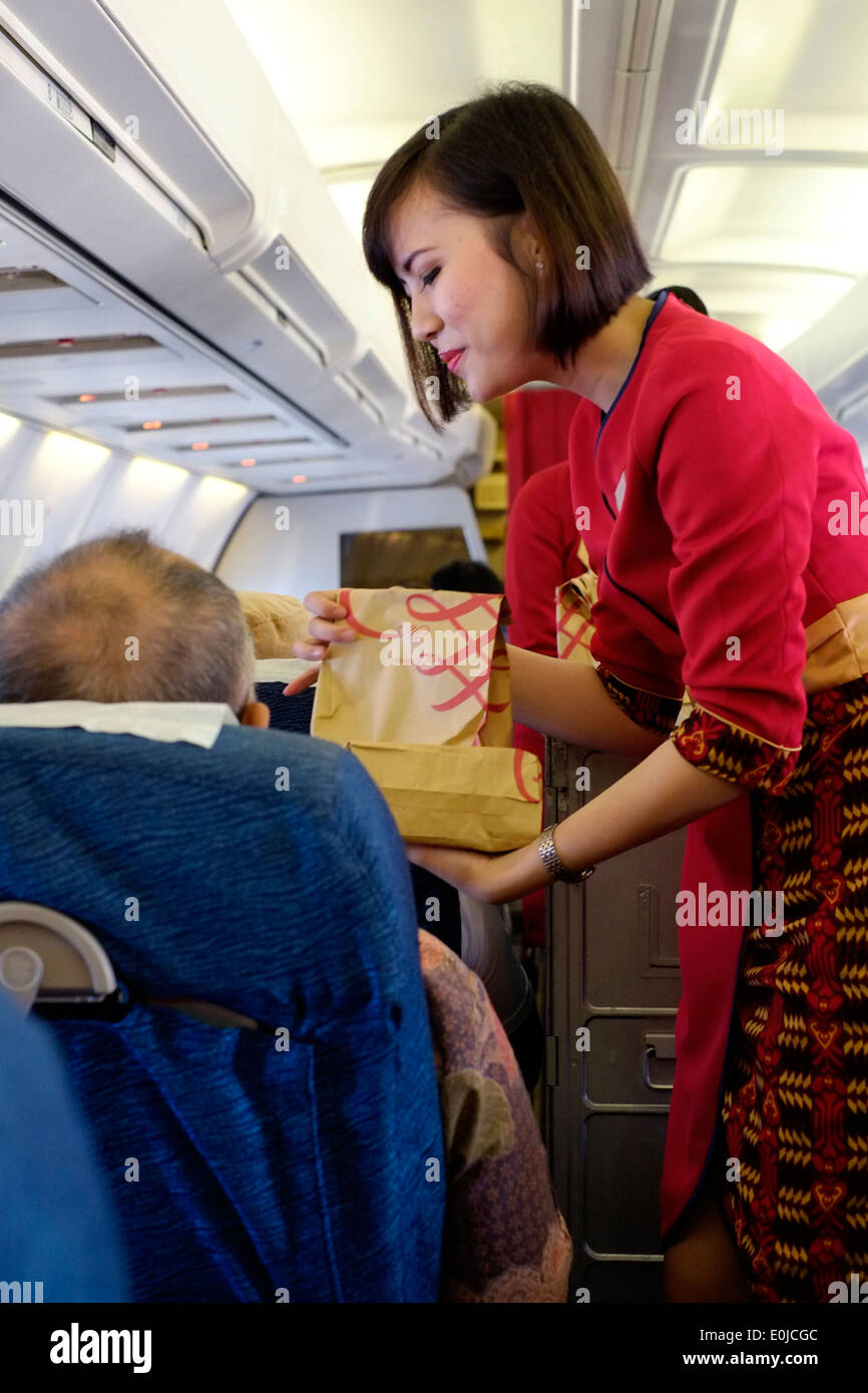 Hostess al lavoro a bordo di una sriwijaya air volo interno en route da Malang a Giacarta indonesia java Foto Stock