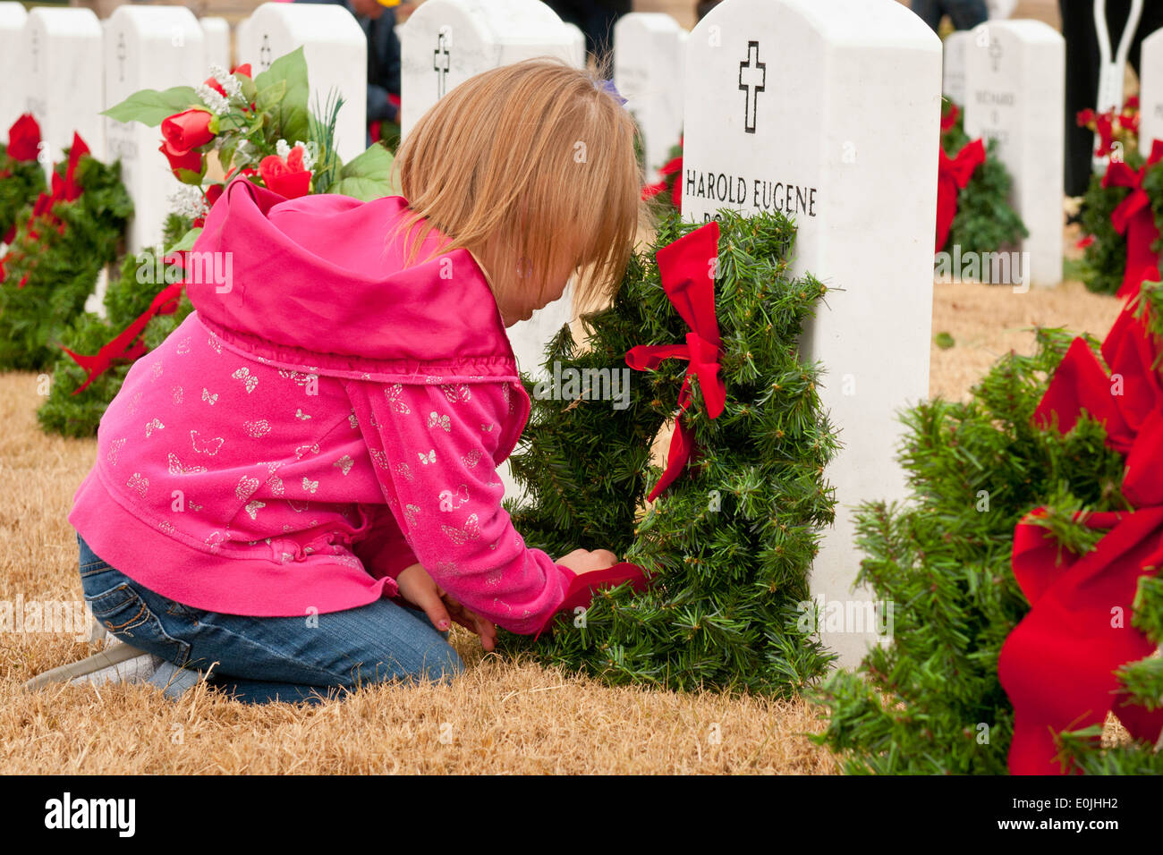 KILLEEN, Texas -- Carley Lawry, 5, pone una corona di fiori su una lapide presso il Texas centrale stato cimitero dei veterani nov. 30, 2013. Foto Stock