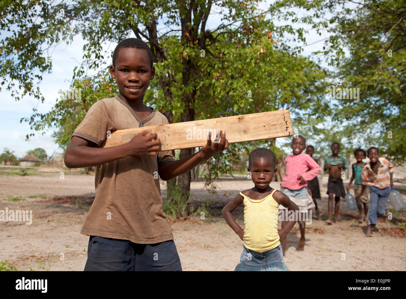 I bambini con selfmade giocattolo di legno chitarra, Okavango Delta, Botswana, Africa Foto Stock