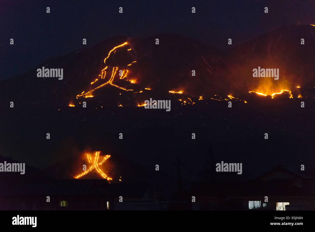 Fire formando due giganti di caratteri cinesi che significa 'fuoco' sul pendio di montagna durante la Festa del Fuoco, Aso, Kumamoto, Kyushu, Giappone Foto Stock