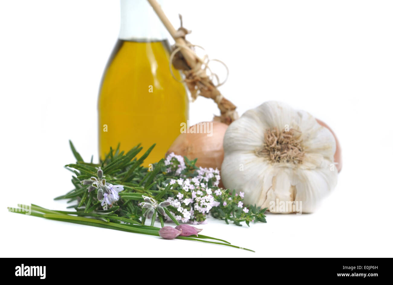 Erbe aromatiche, cipolle, aglio e bottiglia di olio per il condimento Foto Stock