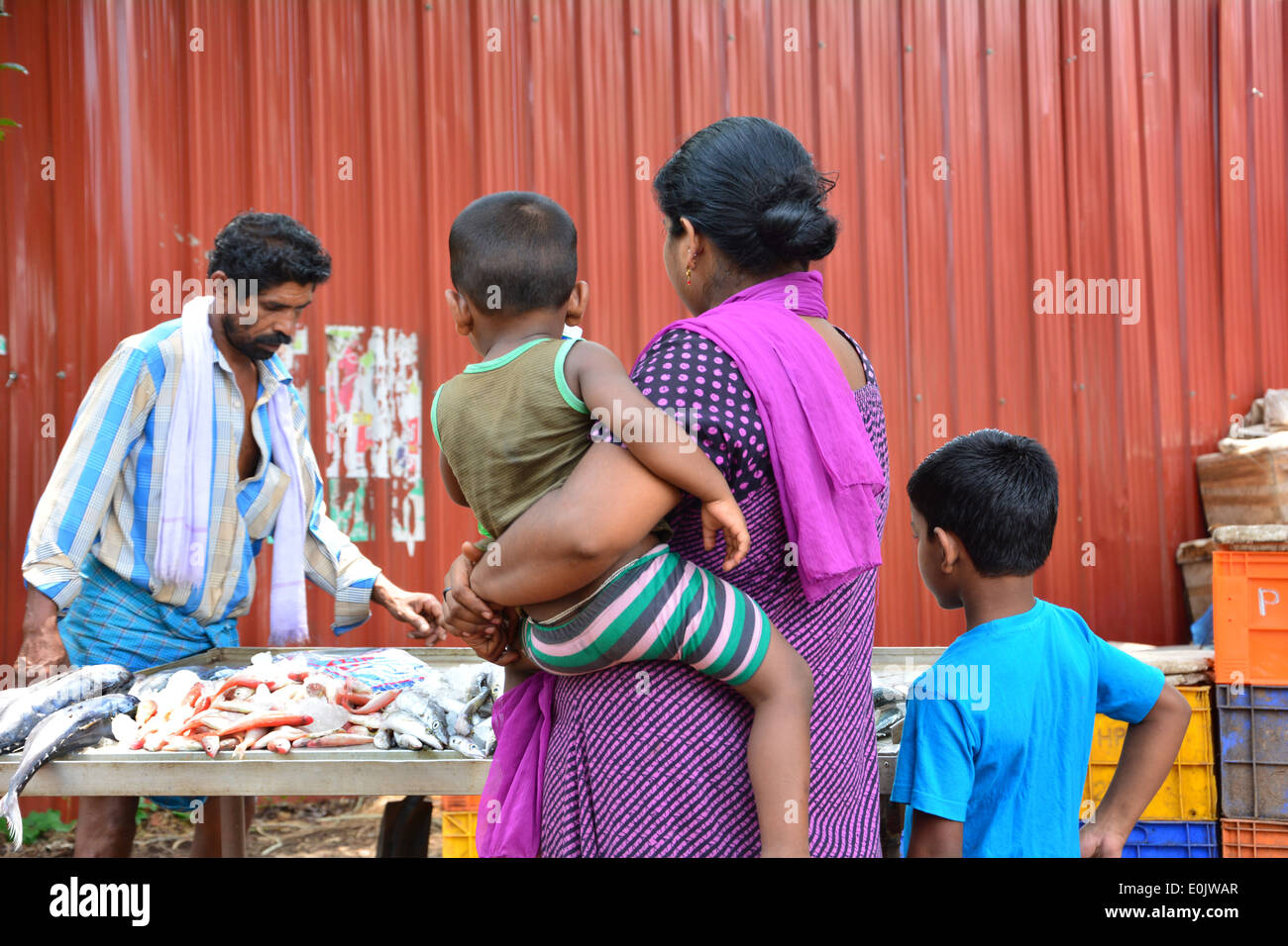 Donna con due bambini acquista il pesce da pescare monger Foto Stock
